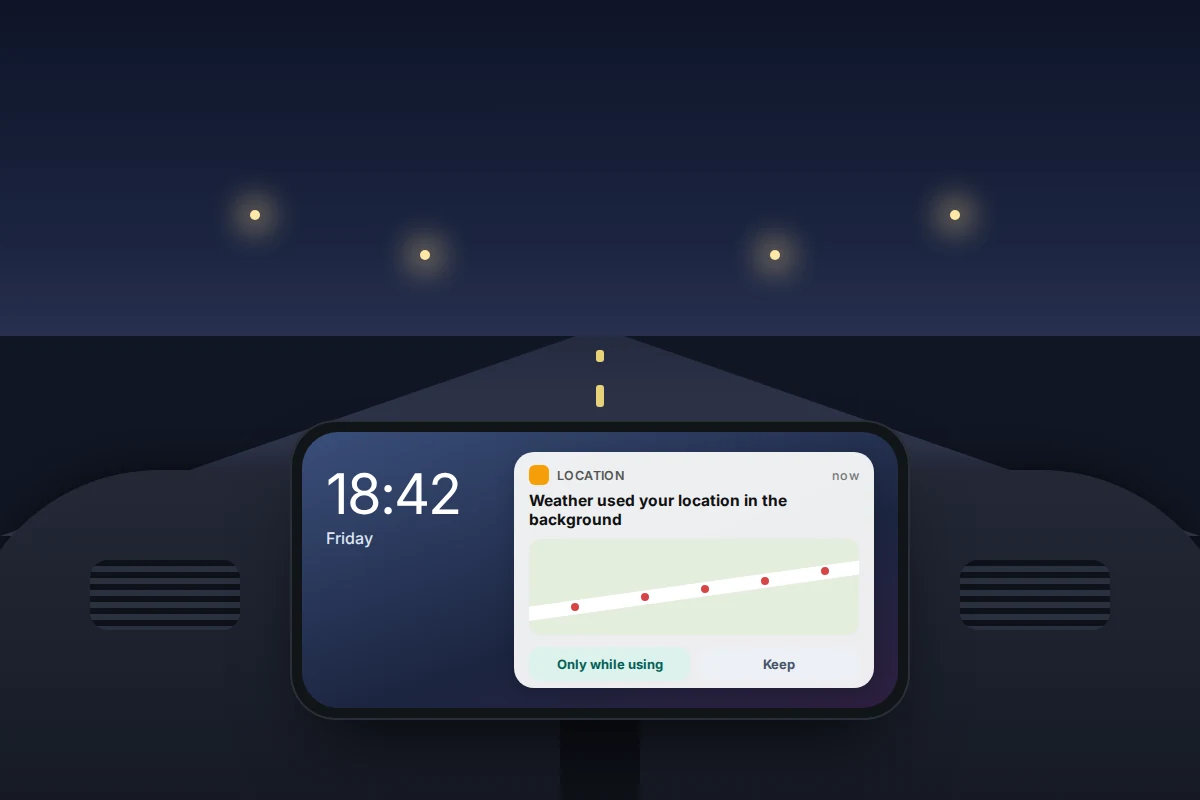 A phone in a car dashboard mount at night showing a notice that an app used location in the background