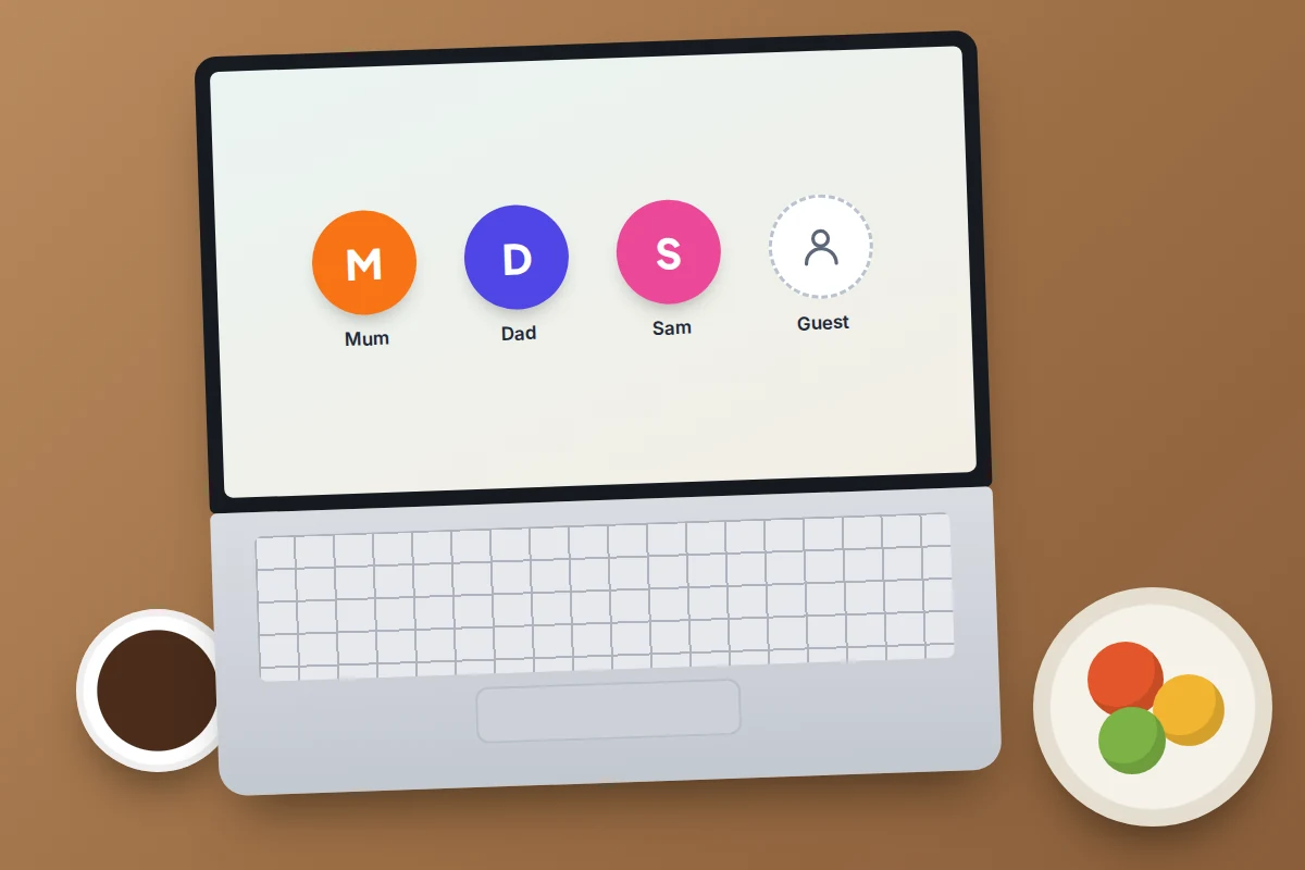 A family laptop on a kitchen table showing separate profile tiles for each person and a guest option