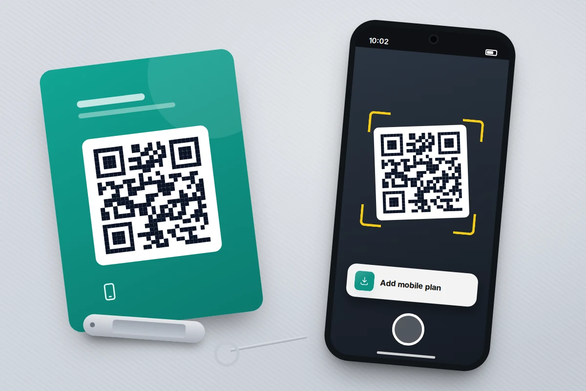 A phone scanning a QR code printed on a small card, with an empty SIM tray and ejector pin beside it