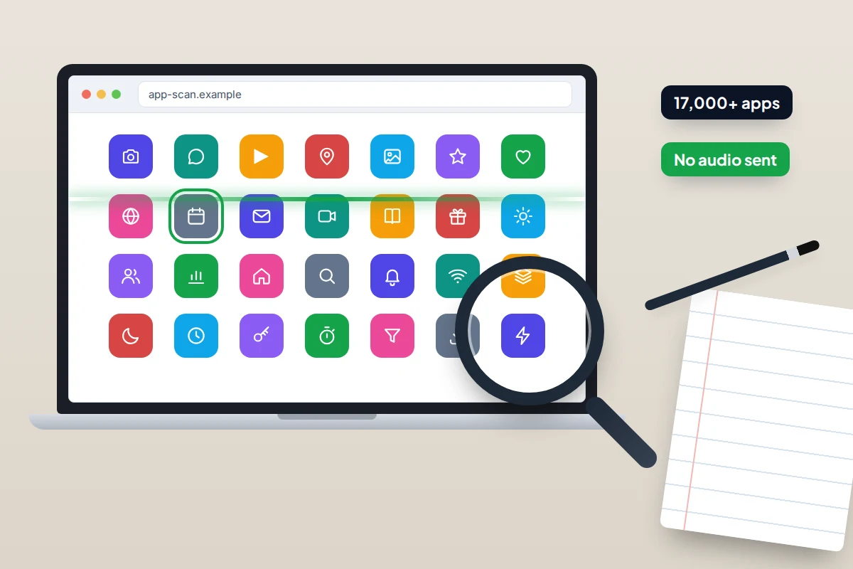 A desk with a laptop showing a grid of app icons being scanned, a magnifying glass and a notebook