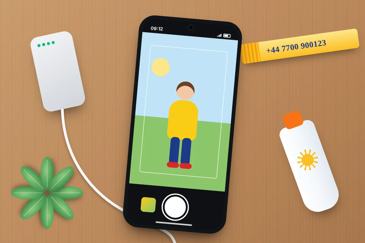 Flat-lay of a phone photographing a child, a power bank with cable, sun cream and a wristband with a phone number