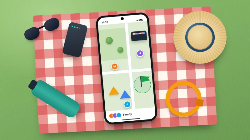 Picnic blanket on grass with a phone showing a family map, a power bank, sun hat, water bottle and a wristband