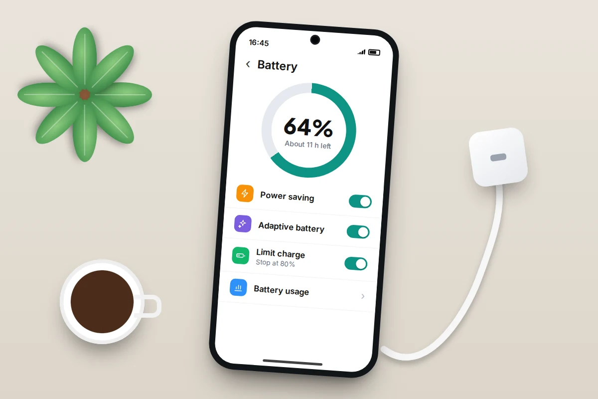 A phone on a desk showing battery settings with power saving, adaptive battery and an 80% charge limit switched on