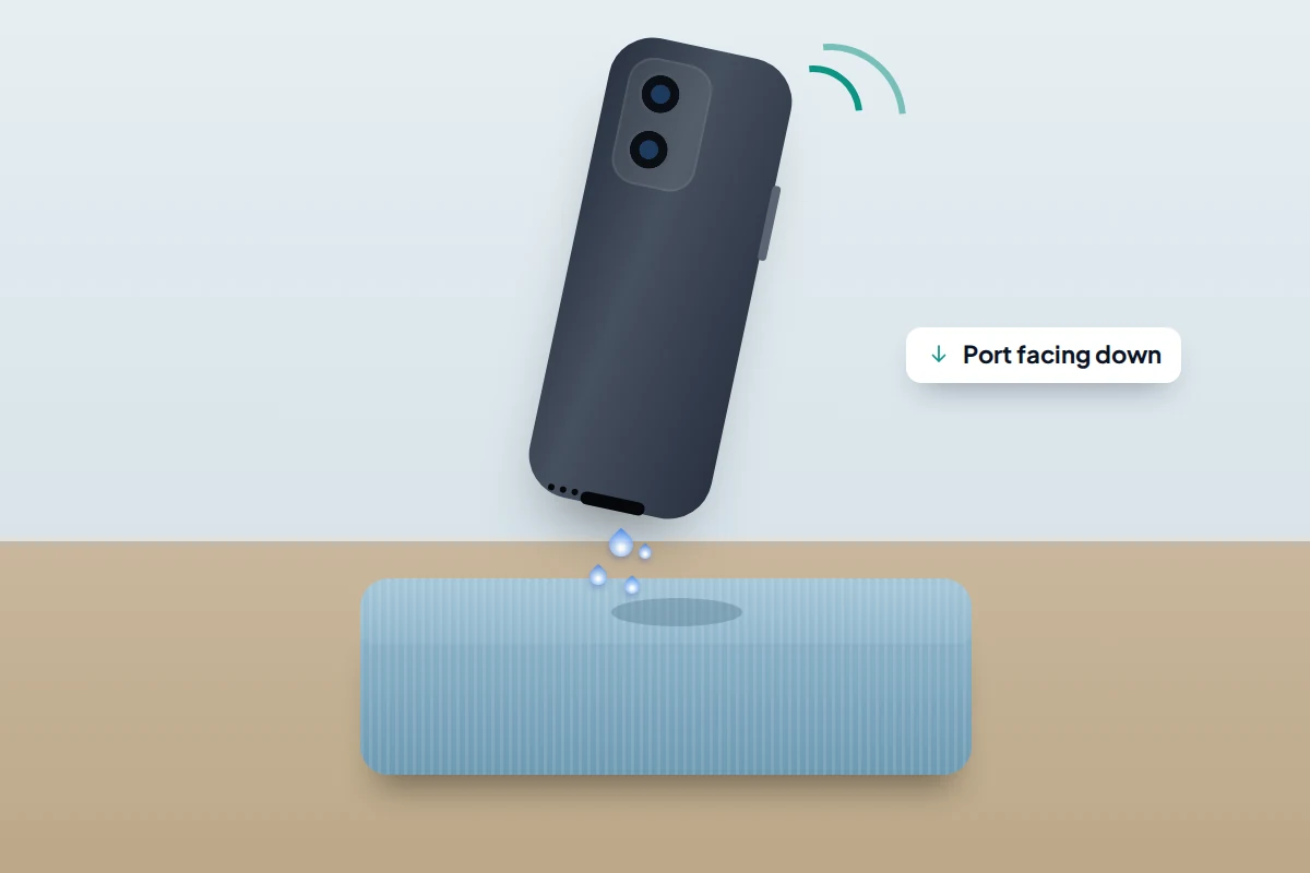 A phone tilted with its charging port facing down above a folded cloth, water droplets falling from the port