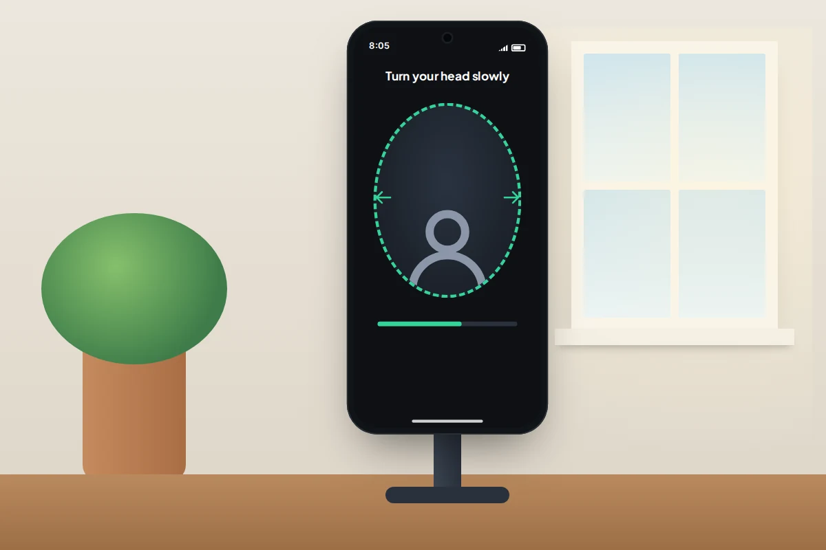 Phone on a stand by a window showing an oval face frame with arrows prompting the user to turn their head