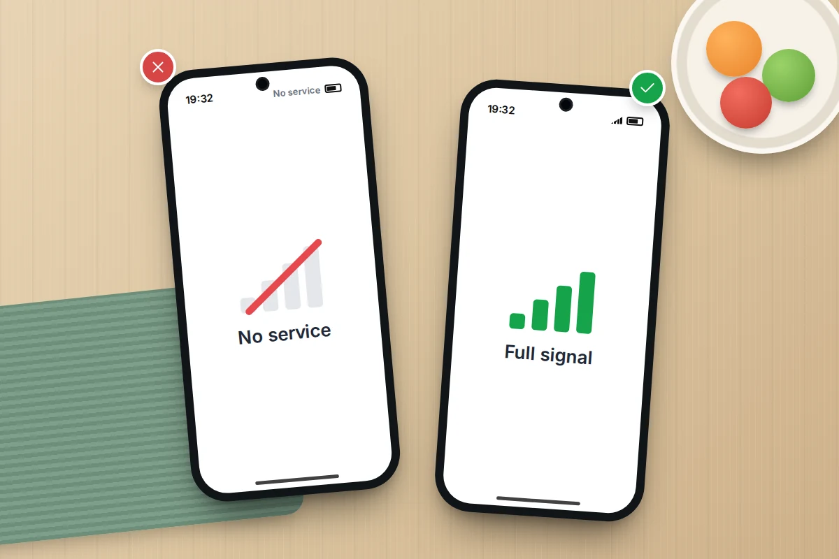 Two phones on a kitchen table: one showing No service with no bars, the other beside it showing full signal