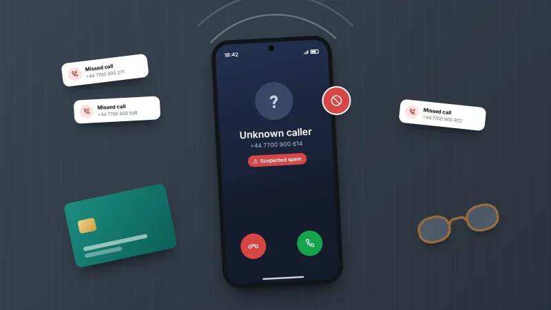 Phone on a dark table showing an incoming call from an unknown number flagged as suspected spam, with missed-call slips around it