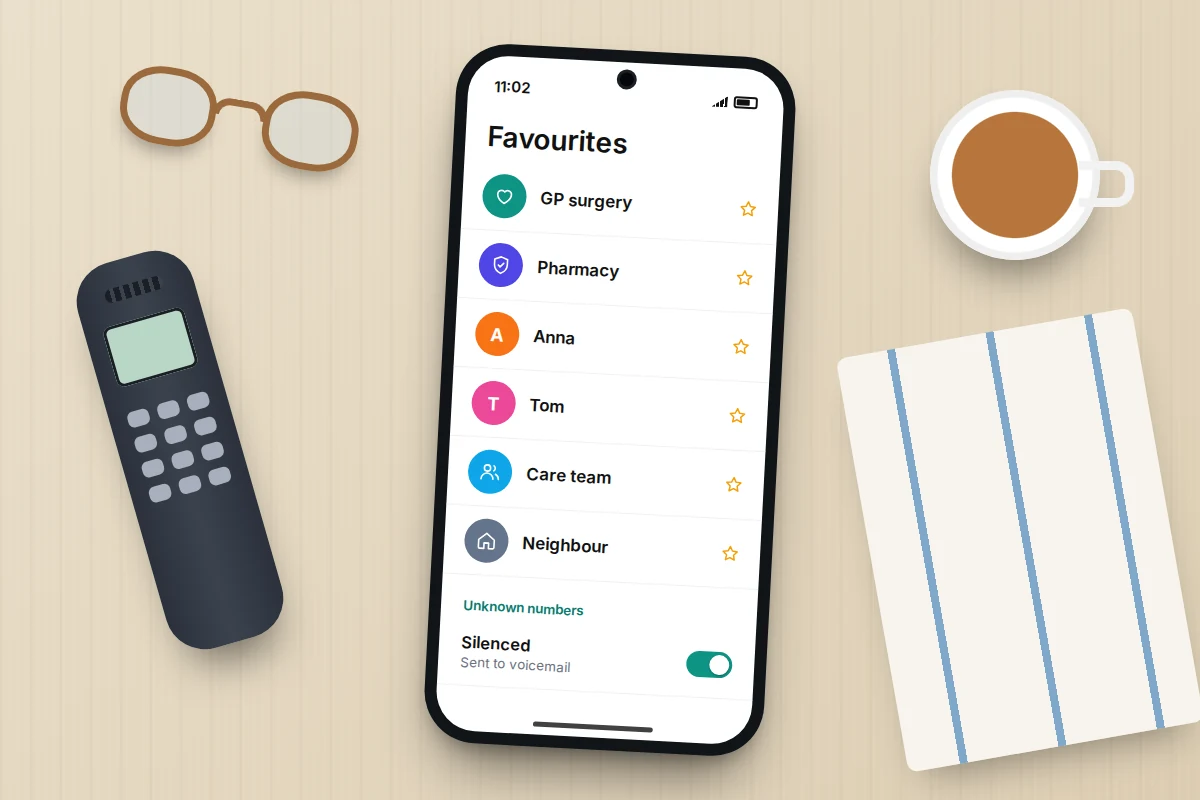 Kitchen table with a landline handset, reading glasses and a phone showing favourites such as GP surgery and pharmacy