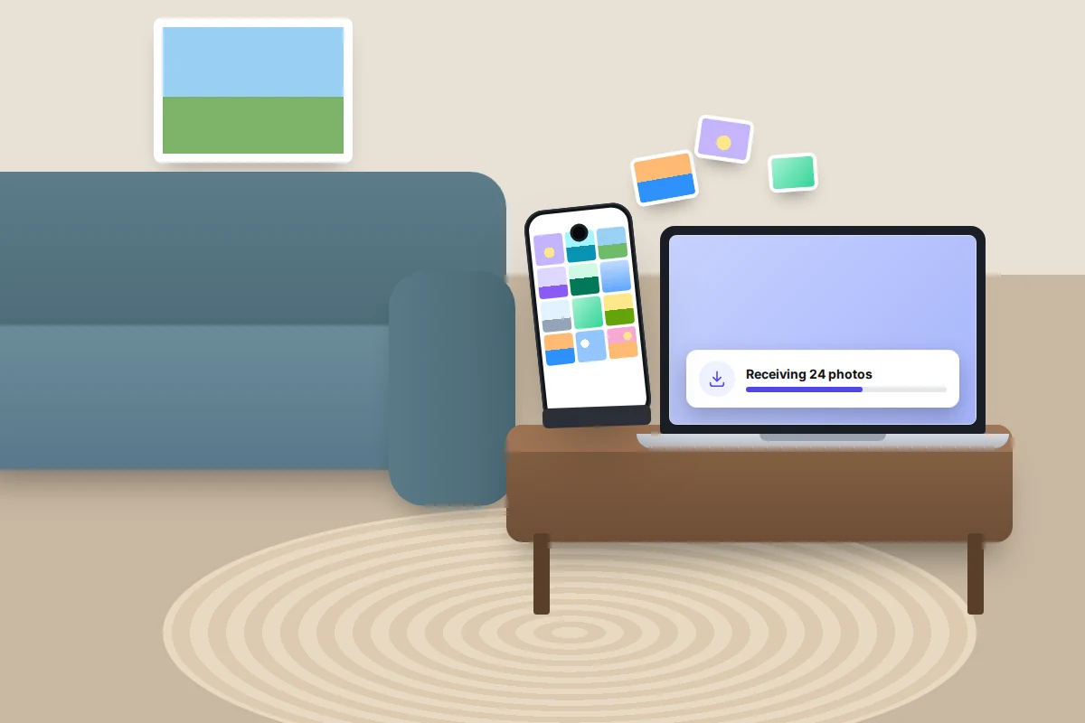 Living room with a phone in a stand on a coffee table sending photos to a laptop that shows a receiving progress bar