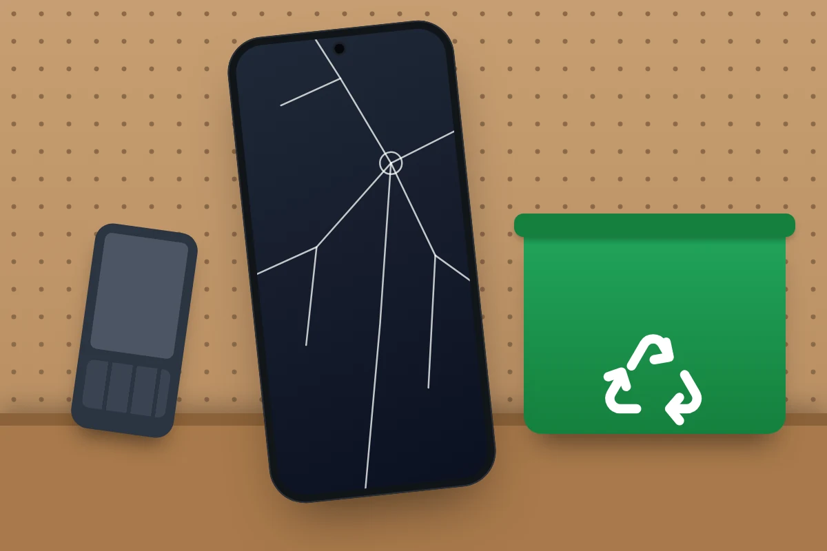 A phone with a cracked screen and an old keypad phone next to a green recycling box on a garage shelf